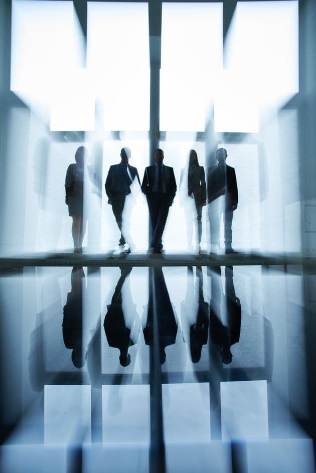 Silhouetted figures walking through warm light